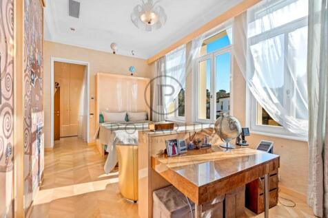 A bright, stylish bedroom features large windows w