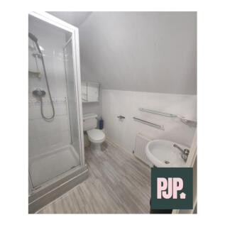 This modern bathroom features a sleek shower, s...