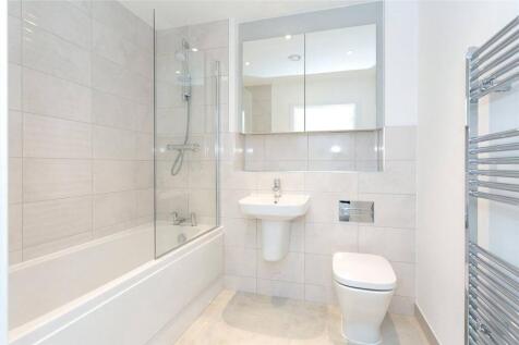 Modern bathroom with full tub and stylish tilin...