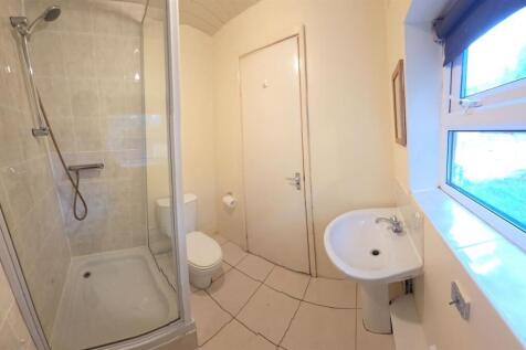 Bright, modern bathroom with a tiled shower enc...