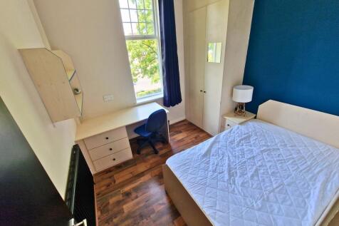 Bright, well-furnished bedroom featuring a comf...