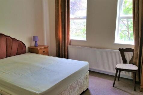 Bright, simply furnished bedroom with a double ...