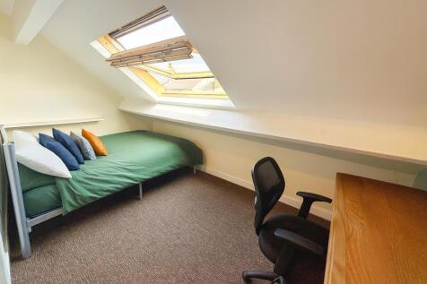 Bright attic single bedroom with a sloped ceili...