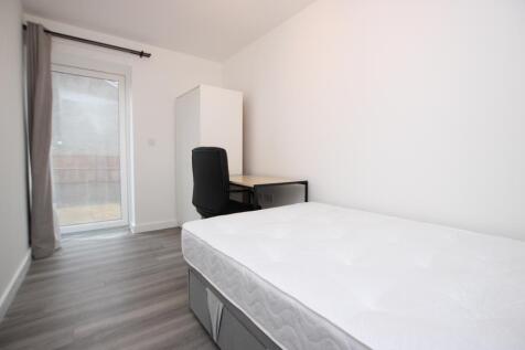 Bright, simply furnished bedroom with a comfort...