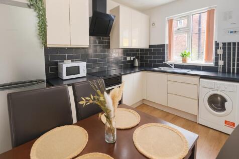 A modern kitchen featuring sleek white cabinetr...