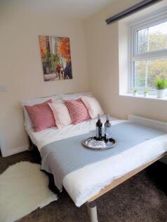 Bright, neatly styled double bedroom with a com...