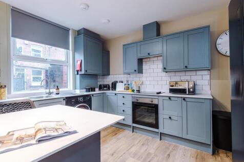 Modern kitchen with blue cabinetry and island...