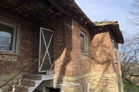 Side perspective of the brick house featuring white-framed windows and a metal staircase leading to an upper door