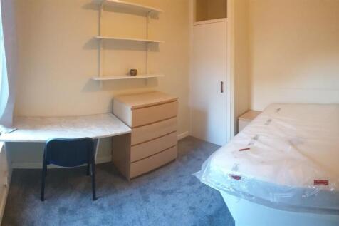 Bright single bedroom with a window-side desk, ...