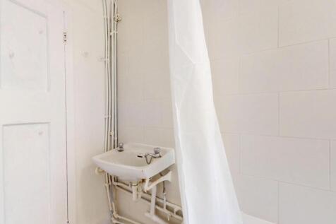 A clean, bright bathroom with a visible shower ...
