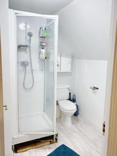 Compact, modern bathroom with a corner shower c...