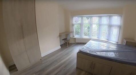 A bright, clean bedroom with a large window all...