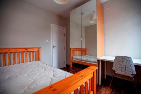 Bright furnished bedroom with desk and wardrobe...