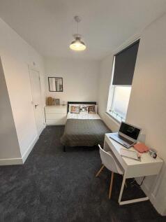 A bright and cozy bedroom featuring a double be...