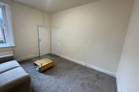 Bright, neutral living room with window and sof...