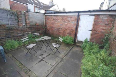 Enclosed paved rear garden with a central seati...