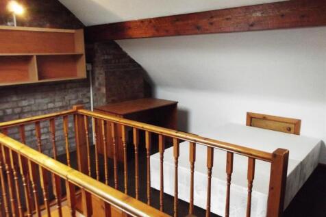Charming loft bedroom with rustic wood beams...