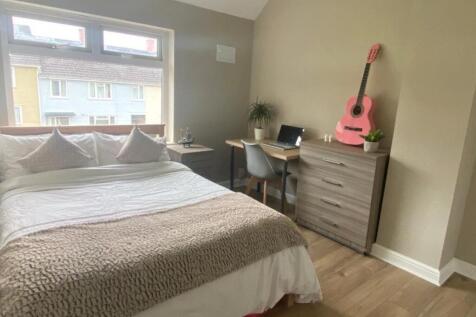 A tidy and well-lit double bedroom featuring a ...