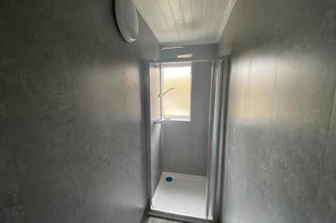 Modern walk-in shower with sleek grey tiling an...
