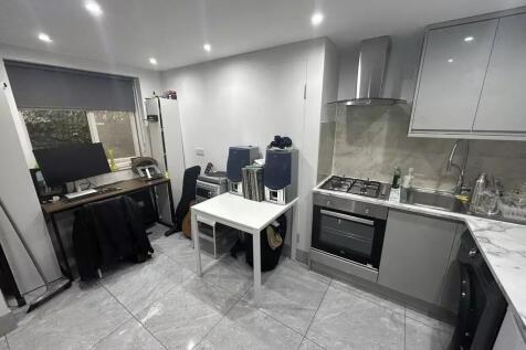 Modern kitchen with study area and tiled floor...