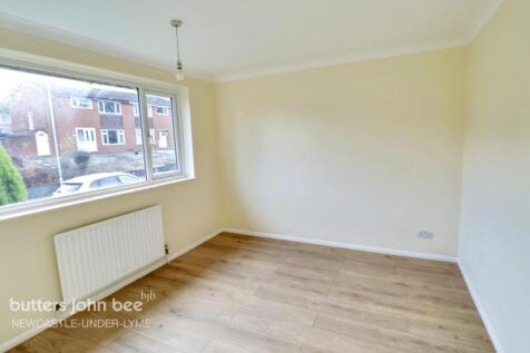 Bright bedroom with large window and wood floor...