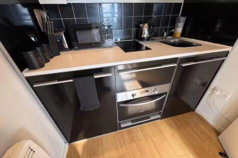 Modern fitted kitchenette with sleek black cabi...