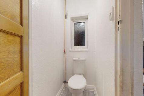 Compact, freshly painted WC with a modern close...