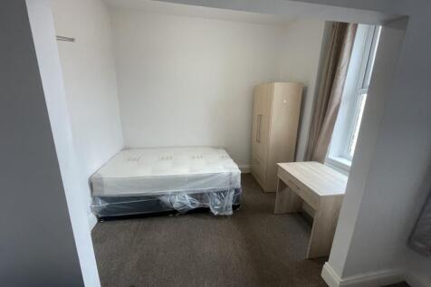 A bright and tidy single bedroom featuring a be...