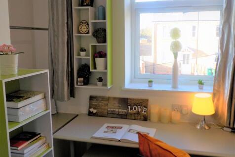 Bright, neatly arranged bedroom study area with...