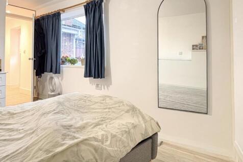 Bright, simply styled bedroom with a comfortabl...