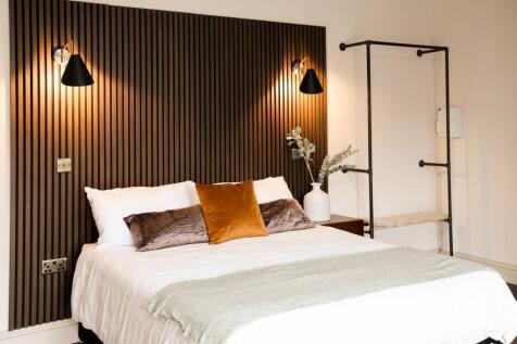 Stylish double bedroom with warm feature wall...