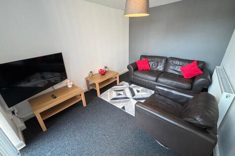 Bright, modern living room with a leather sofa ...