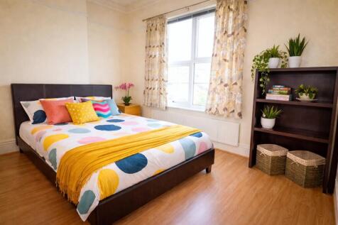Bright, neatly styled double bedroom with colou...