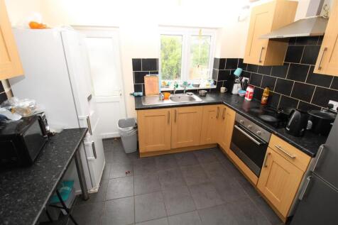 Bright kitchen with modern black tiling and ove...