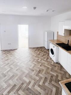 Bright open-plan kitchen area with modern white...