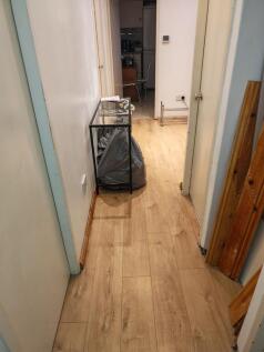 Bright hallway featuring modern wood-style floo...
