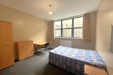 Bright, simply furnished bedroom with a large w...