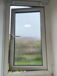 Compact frosted casement window with a white uP...