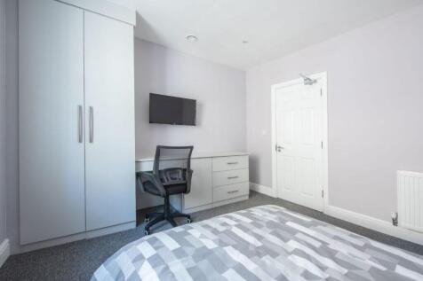 Modern bedroom with sleek desk and storage...