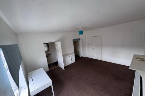 A bright and spacious living room featuring lar...