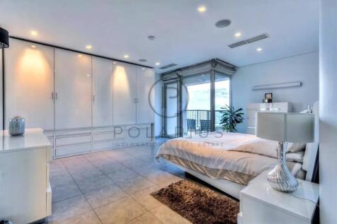 Modern bedroom with sleek white furniture, large b