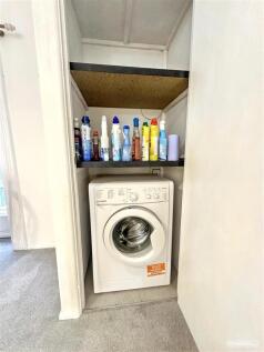 Convenient laundry area with storage shelving...