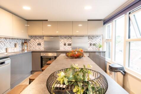Modern kitchen with a long central island, slee...