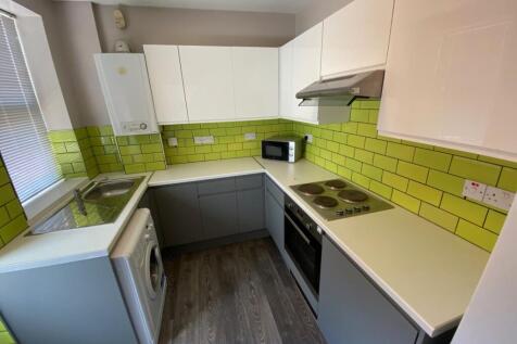 A bright and modern kitchenette with stylish gr...