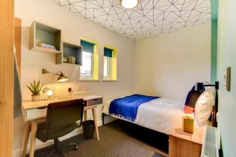 Bright, modern single bedroom with a neatly mad...