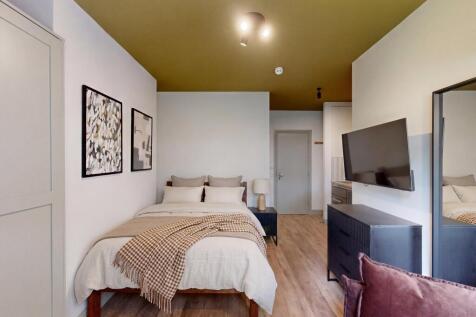 Stylish bedroom with large TV and modern decor...