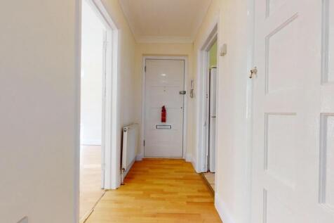 Bright and tidy hallway with warm wood floors...
