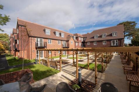 a brick building with a patio and chairs in front of it