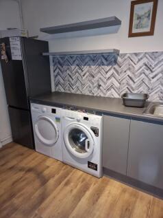 Modern utility-style kitchen area with integrat...