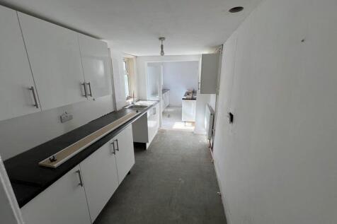 Bright kitchen featuring white cabinetry and bl...
